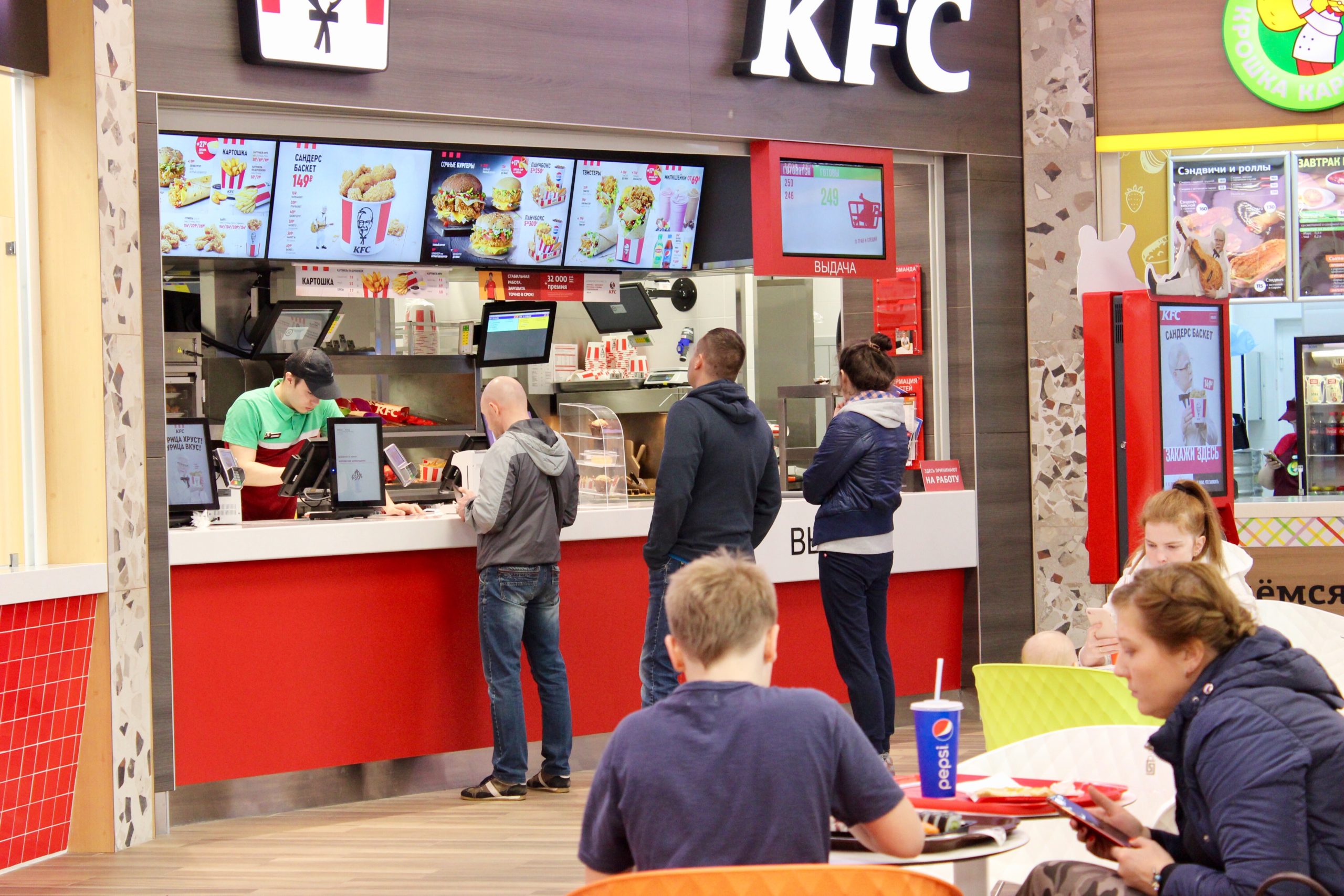 Homem em uma fila comprando comida em uma rede de fastfoods